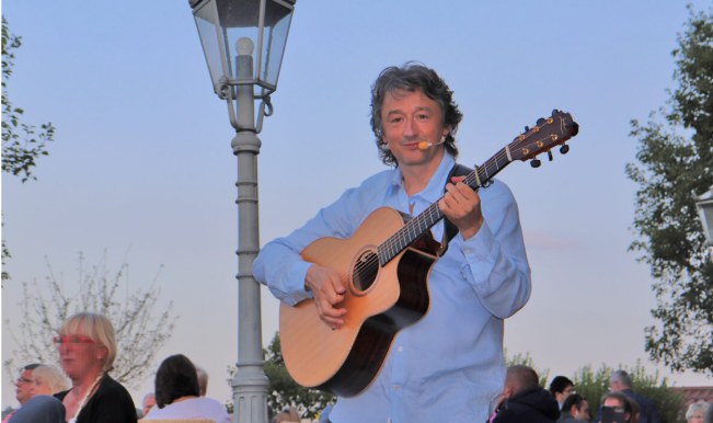 Mike Janipka spielt Gitarre im Freien vor Publikum